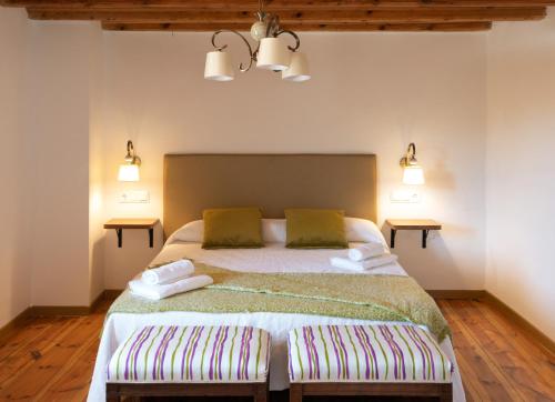 a bedroom with a large bed with two pillows at Casa Rural Pozo Roñañuela in El Royo