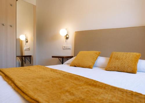 a bedroom with a large white bed with yellow pillows at Casa Rural Pozo Roñañuela in El Royo