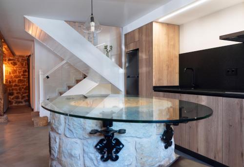 una mesa de cristal en una habitación con escalera en Casa Rural Pozo Roñañuela en El Royo