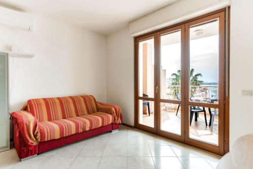 sala de estar con sofá y puerta corredera de cristal en Flat358, en Alghero