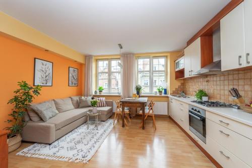 a kitchen and living room with a couch and a table at Mariacki View Apartment in Gdańsk