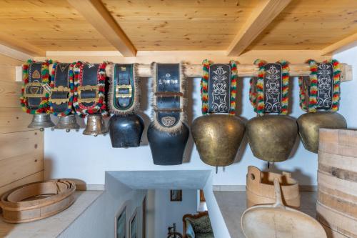 a group of pots and bells hanging on a wall at Ferienbauernhof Berlinger in Au im Bregenzerwald