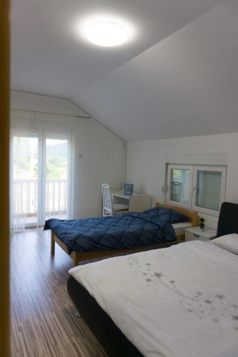 a bedroom with two beds and a table and a window at Vila za odmor Svitavac in Trebinje