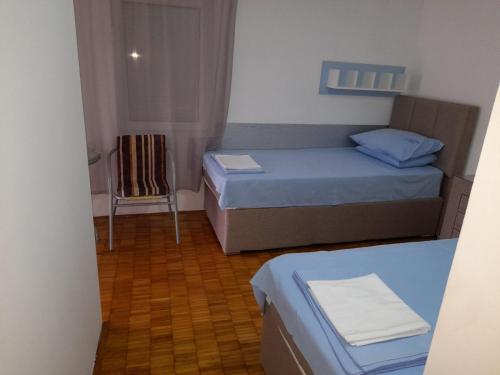 a small room with two beds and a chair at Ana in Budva