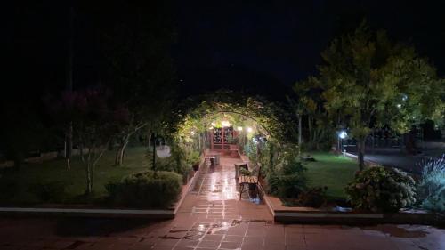 a park with benches and an arch at night at Alma Migrante bed&wine in Telese