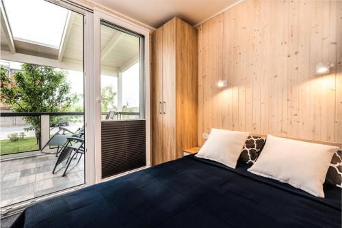 une chambre avec un lit et une grande fenêtre dans l'établissement Nasze Wybrzeże, à Sarbinowo