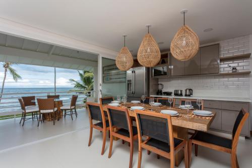 an open kitchen and dining room with a table and chairs at Apartamento Luxuoso à Beira-mar em Praia do Forte in Praia do Forte
