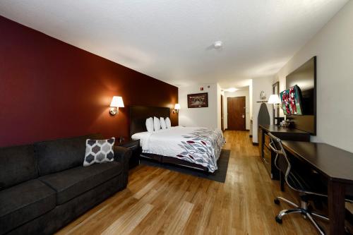 a hotel room with a bed and a couch at Red Roof Inn Osage Beach - Lake of the Ozarks in Osage Beach