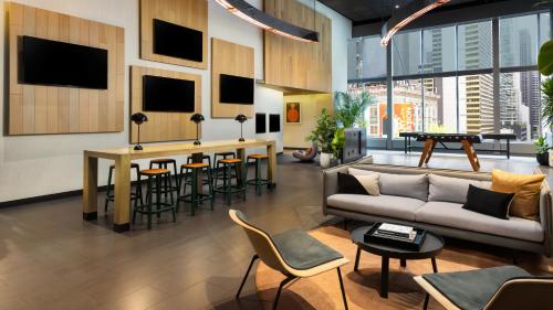a living room with a couch and a bar with stools at M Social Hotel Times Square New York in New York