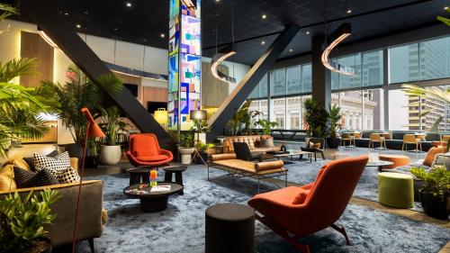a lobby of a building with chairs and tables at M Social Hotel Times Square New York in New York