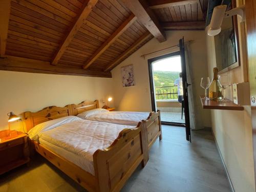 una camera con un grande letto in legno e un balcone di Hotel Monte Baldo a Brenzone sul Garda