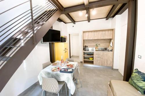 a dining room with a table and a kitchen at New Agriloft 4 Palms clima, giardino e Wi-Fi a 50 mt dal mare in Bordighera