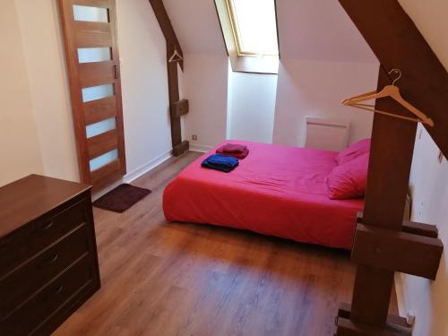 1 dormitorio con cama roja y ventana en Le Gîte du Parc, en La Coquille