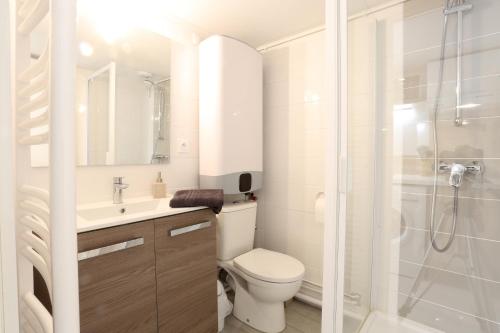 La salle de bains blanche est pourvue d'une douche et de toilettes. dans l'établissement T2 avec terrasse / 10mn grande plage, à Royan