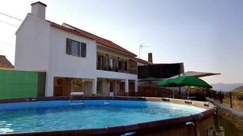 a swimming pool in front of a house at Casa das Lajes - Alojamento Local in Vila Nova de Foz Coa