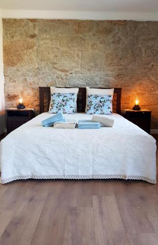 a bedroom with a large white bed with two lamps at Casa das Lajes - Alojamento Local in Vila Nova de Foz Coa