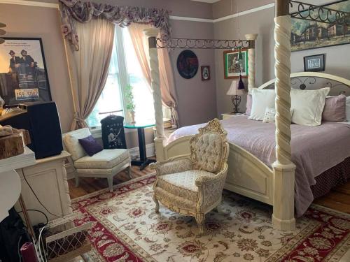 - une chambre avec un lit à baldaquin et une chaise dans l'établissement Inn Upon Moon River Plantation, à Chester