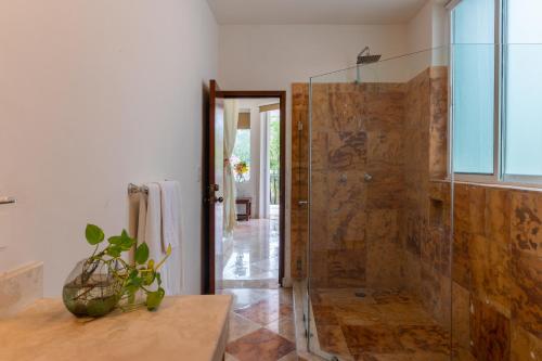 a bathroom with a shower with a glass door at Villa Palmeras in Cancún
