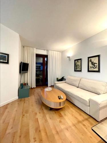 a living room with a white couch and a coffee table at Apartament Jurata 30 in Jurata