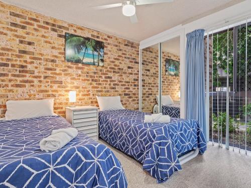una camera con due letti e un muro di mattoni di Bay Parklands, 56 2 Gowrie Ave - ground floor, air conditioned, wifi & Foxtel a Nelson Bay