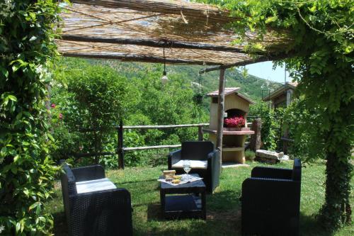 a pergola with chairs and a table in a yard at Agriturismo Cardella in Piobbico