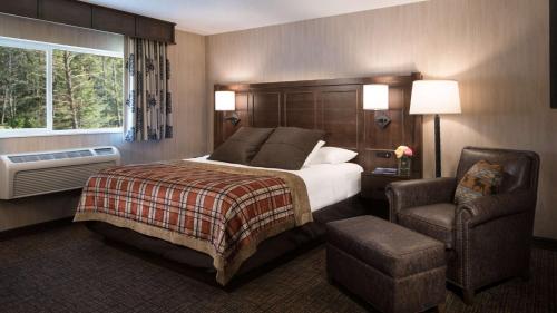 a hotel room with a bed and a chair at Best Western Plus Flathead Lake Inn and Suites in Kalispell
