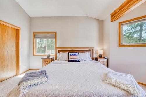 a bedroom with a large bed and two windows at Sunset Mountain Retreat in Sunriver