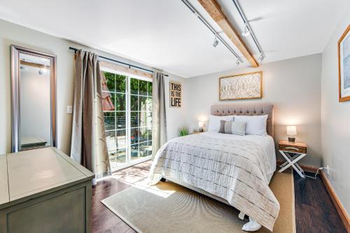 a bedroom with a bed and a large window at Orchard Near the River Escape in Forestville