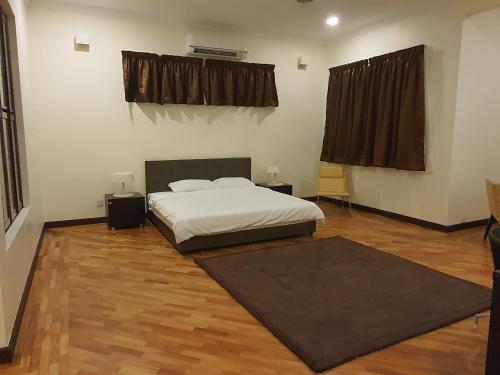 um quarto com uma cama e piso em madeira em PH Homestay Bungalow House at PJ Fully Equipped em Petaling Jaya