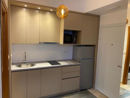 a small kitchen with a sink and a refrigerator at Bitcoin and Ethereum Deluxe Apartments in Bar