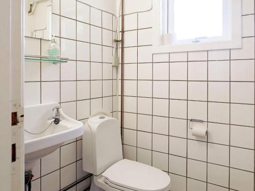 a white bathroom with a toilet and a sink at Holiday home Rørvig VIII in Rørvig