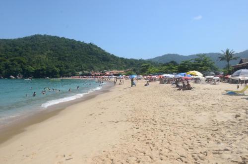 a beach with a bunch of people in the water at Pousada Refugio do Pirata in Trindade