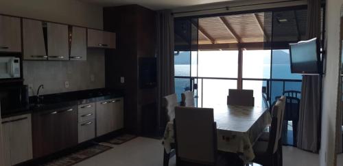 a kitchen with a table and a view of a balcony at Marques Home in Porto Belo