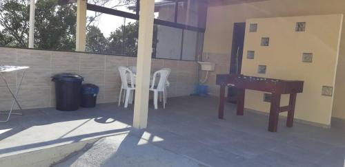 a patio with a table and chairs and a desk at Marques Home in Porto Belo