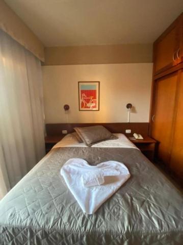 a bedroom with a bed with a heart shaped object on it at Condominio Residencial pousada do Serran0 in Gramado