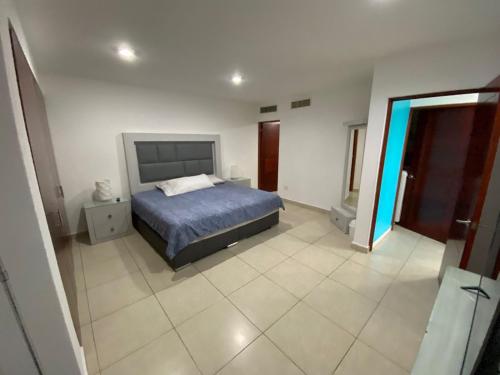 ein Schlafzimmer mit einem Bett und einem gefliesten Boden in der Unterkunft Costa Veleros Marina Mazatlán 03 in Mazatlán