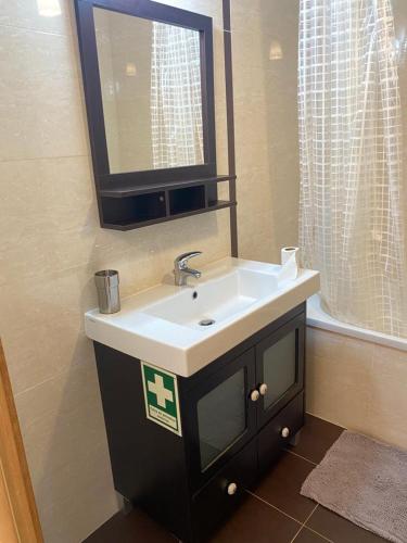 a bathroom with a sink and a mirror at Sunset House / Casa Por do Sol in Nazaré