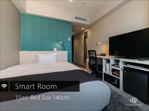 a bedroom with a bed and a flat screen tv at DEL style Fukuoka Nishinakasu by Daiwa Roynet Hotel in Fukuoka