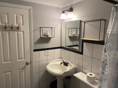 een witte badkamer met een wastafel en een spiegel bij Gorgeous Seaside Seashell Cottage! in Hudson