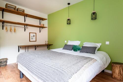 - une chambre avec un grand lit aux murs verts dans l'établissement Frenchyhomes☆villadeluxe☆Plage☆piscine, à Andernos-les-Bains