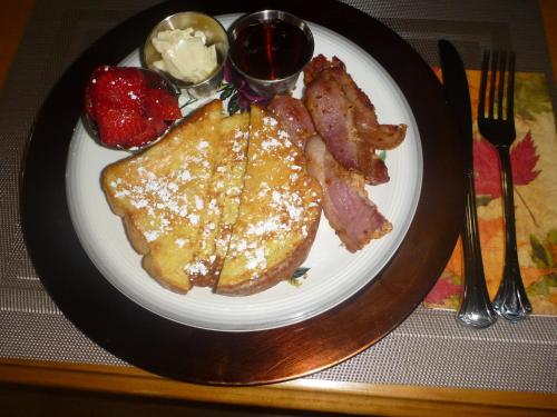 um prato de comida com torradas e bacon em Back Home Bed and Breakfast em Membertou