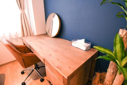 a dressing table with a mirror and a chair at GATEWAY MAIZURU in Maizuru