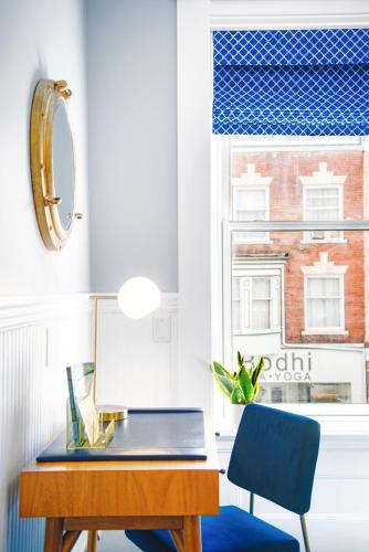 a desk with a blue chair and a window at The Hudson Whaler in Hudson
