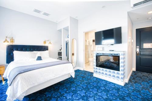 a bedroom with a bed and a fireplace and a tv at The Hudson Whaler in Hudson