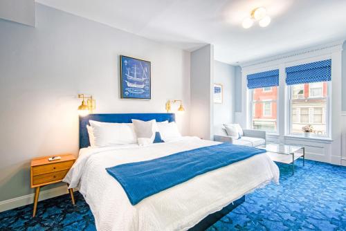 a bedroom with a blue and white bed and a window at The Hudson Whaler in Hudson