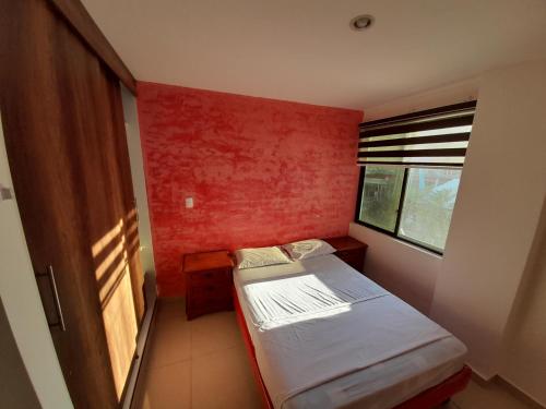 a small room with a small bed and a window at Espectacular departamento de tres habitaciones en Edificación Amaralto in Manta