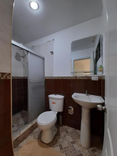 a bathroom with a toilet and a sink at Espectacular departamento de tres habitaciones en Edificación Amaralto in Manta
