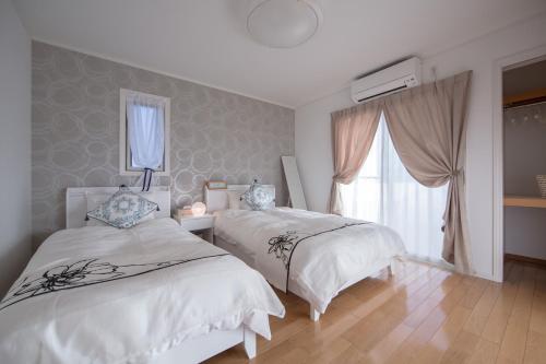 En eller flere senger på et rom på Hills Villa Miyakojima