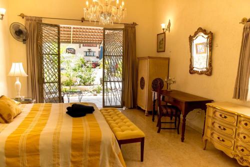a bedroom with a bed and a desk and a table at Casa Palmas by Majikal B&B in Mérida
