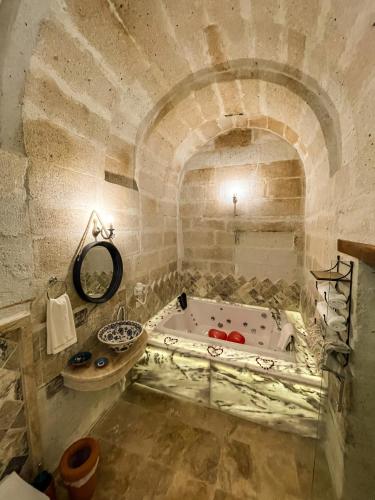 a bathroom with a bath tub and a sink at Kemerli House in Avanos